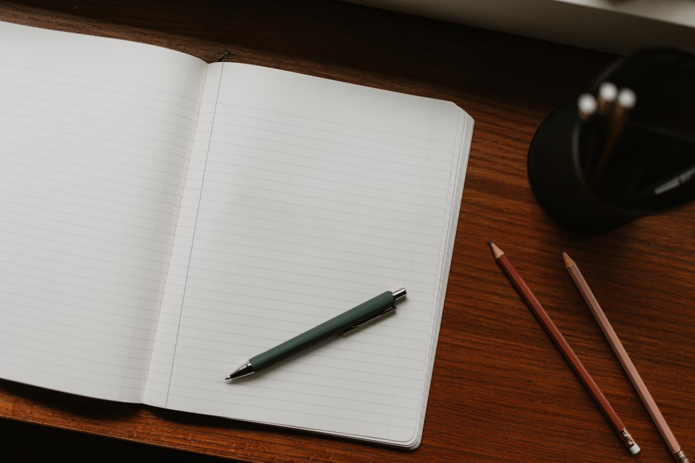 Masada açık defter, kalem ve kurşun kalemlerle planlama